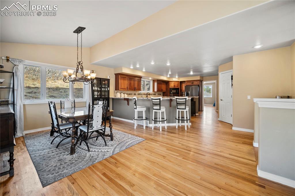 Image 12 of 48: Spacious kitchen with breakfast bar and separate dining space. Hardwood flo