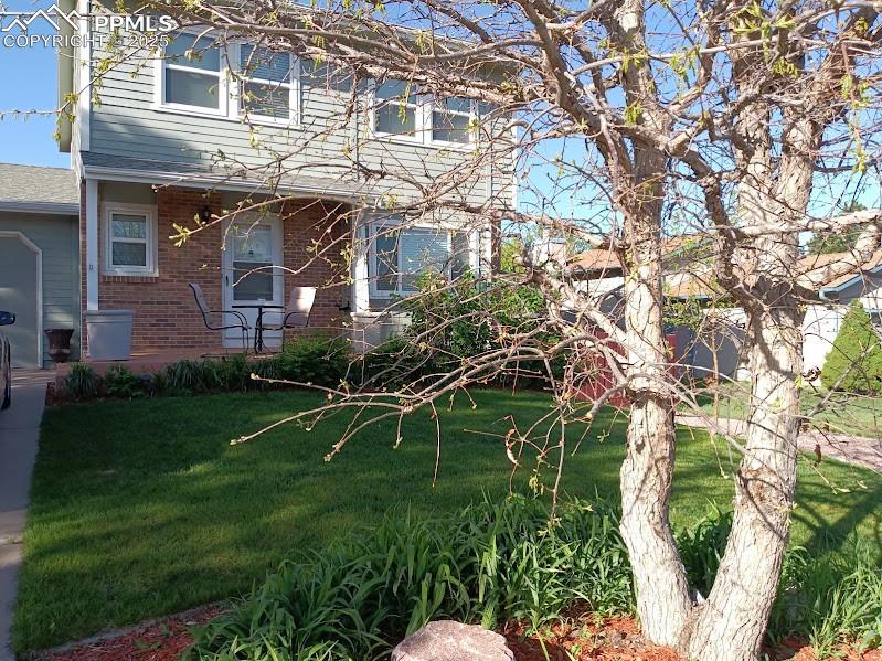 Image 2 of 38: View of front facade with brick siding and a front yard
