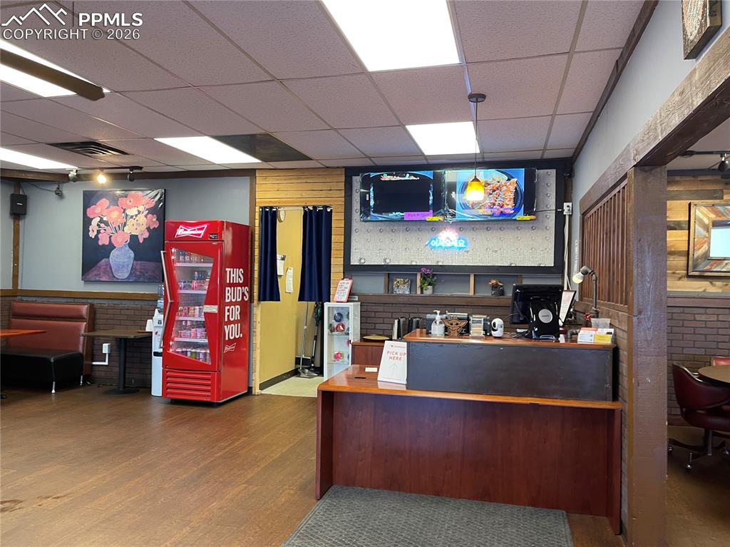 Image 3 of 9: Reception area with a drop ceiling and a wainscoted wall