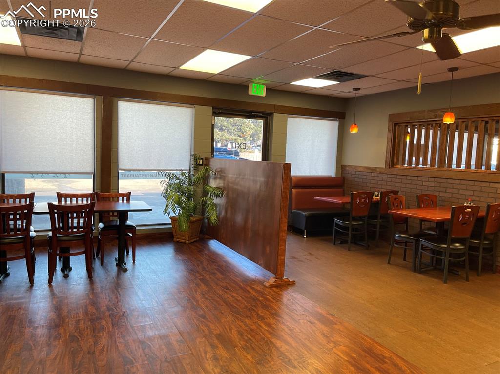 Image 4 of 9: Dining room with a drop ceiling and wood finished floors