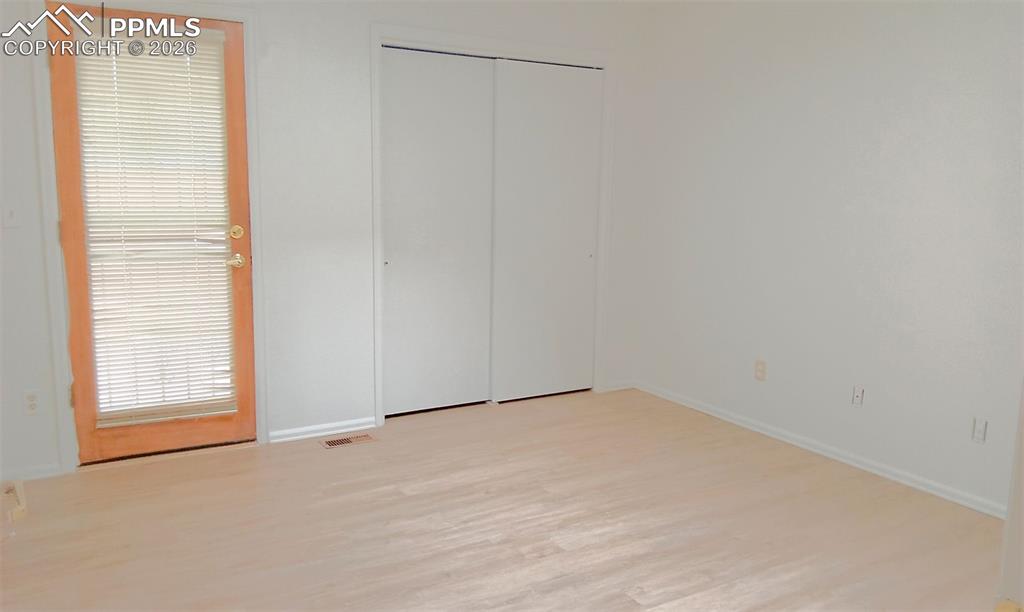 Image 12 of 13: 2nd bedroom with entrance to back deck