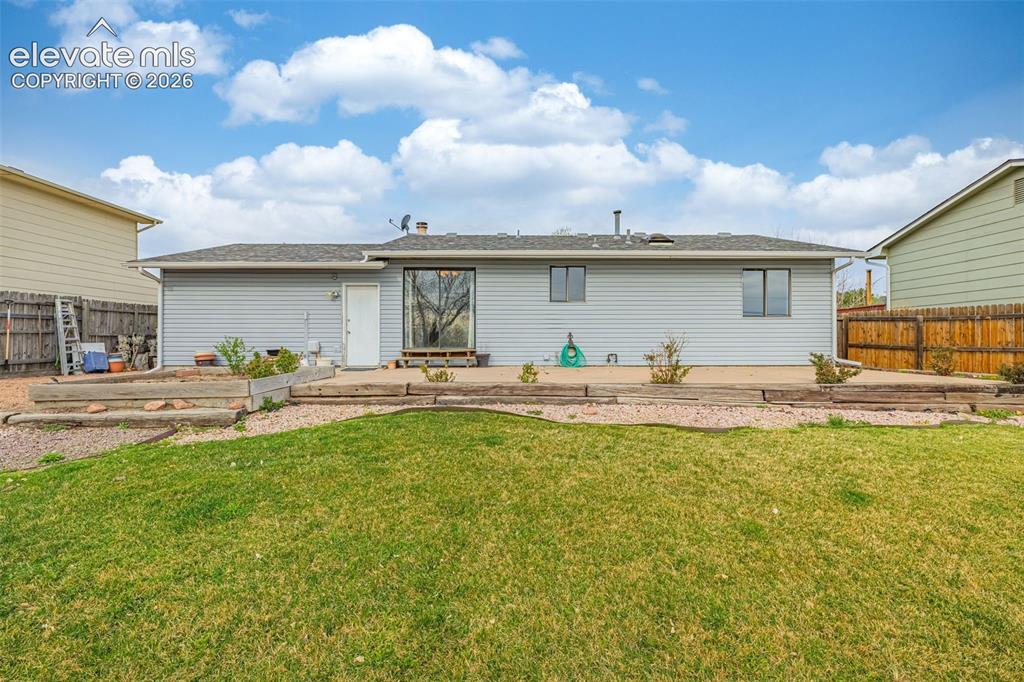 Image 18 of 21: Back of house features fenced yard, concrete patio, flat grassy space and p