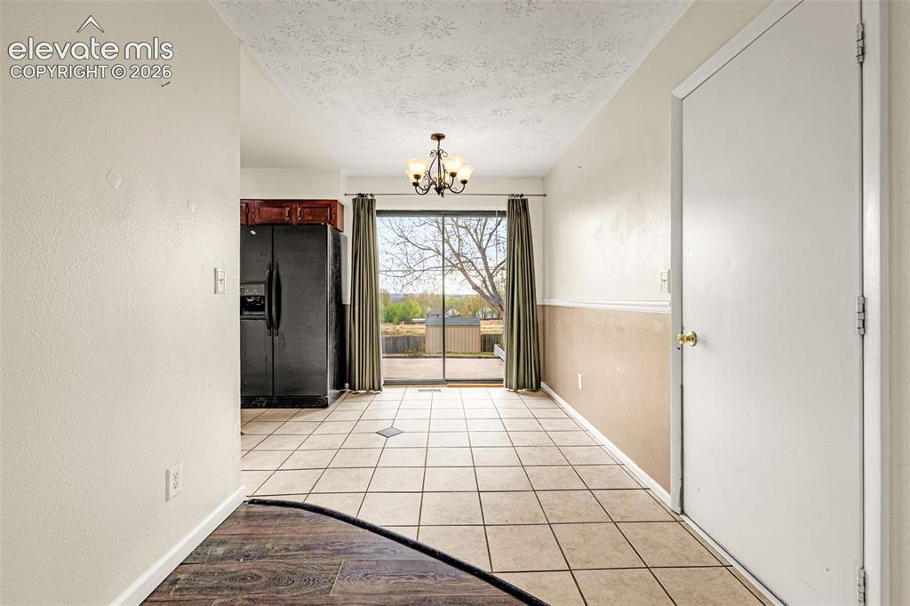 Image 9 of 21: Dining area with walkout to back patio, tile floor and door to garage