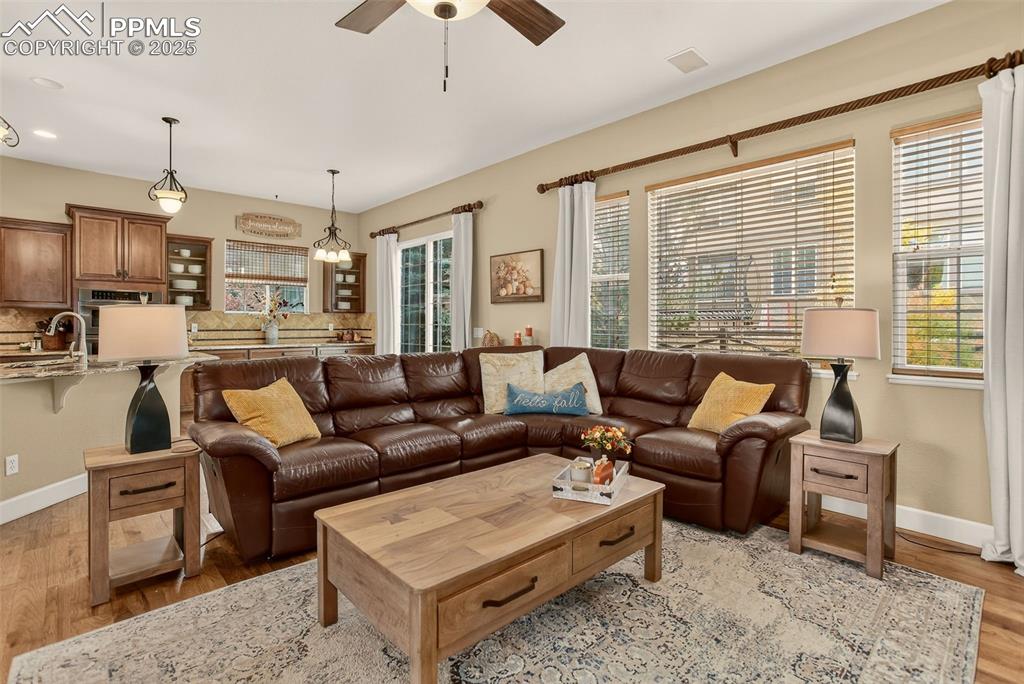 Image 12 of 40: Living room featuring light wood-type flooring and a ceiling fan
