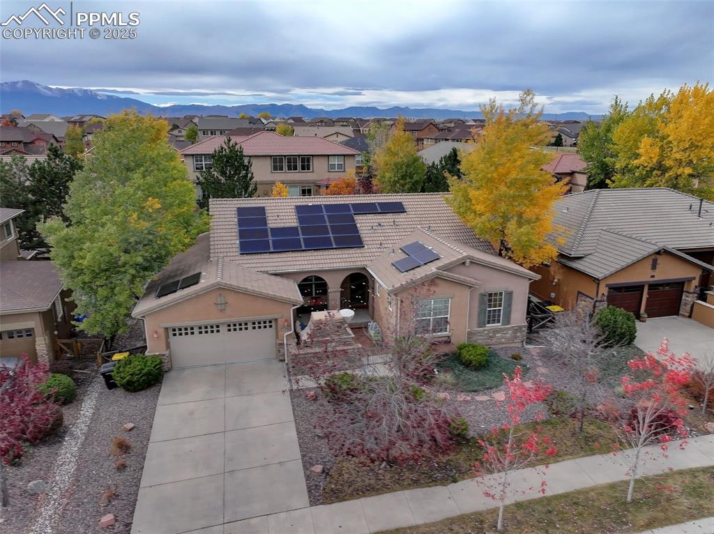 Image 31 of 40: View of front facade with solar panels, concrete driveway, an attached gara