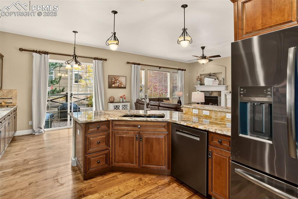 Image 9 of 40: Kitchen with appliances with stainless steel finishes, pendant lighting, li
