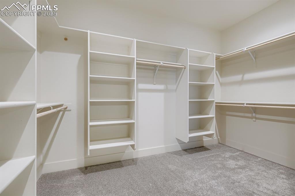 Image 15 of 41: Expansive primary bedroom walk-in closet provides abundant storage and orga