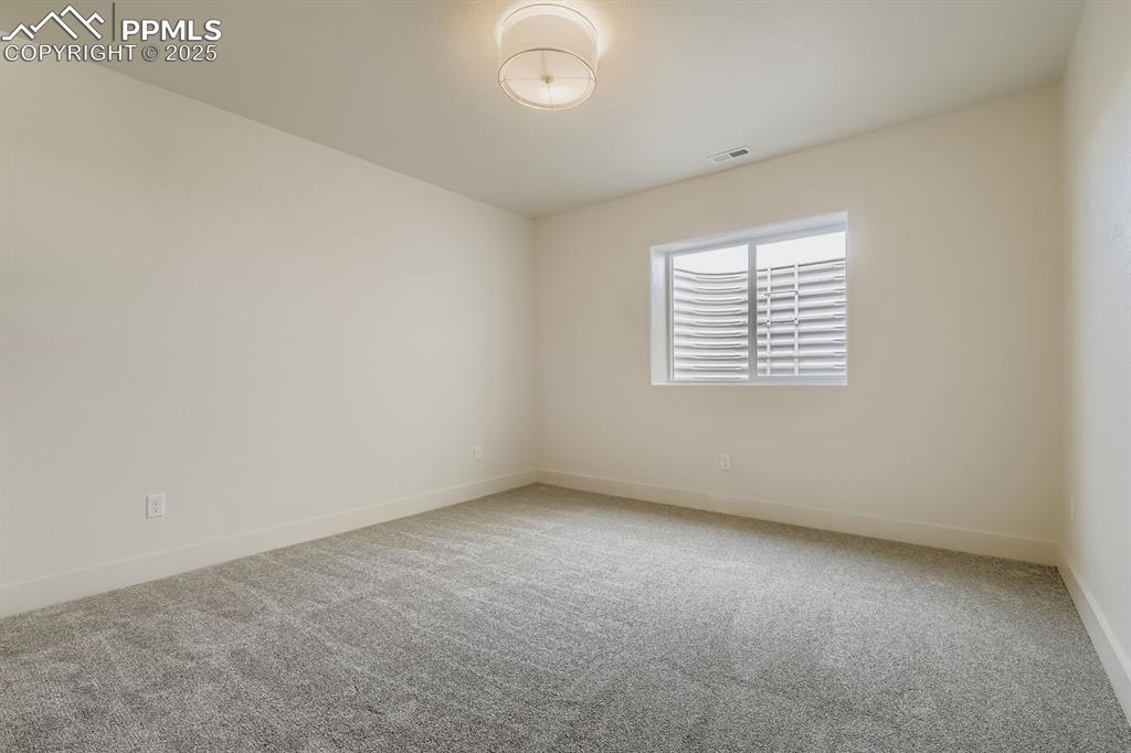 Image 18 of 41: Generously sized basement bedroom with great natural light—ideal for guests