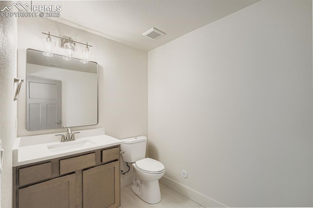 Image 20 of 41: Convenient half-bath just off the basement family/rec area for guests and e