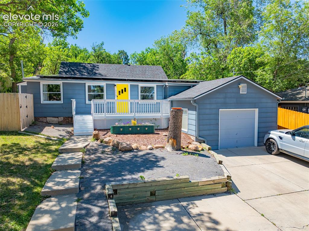 Image 1 of 21: Blue exterior with a vibrant yellow entry door and white porch railing