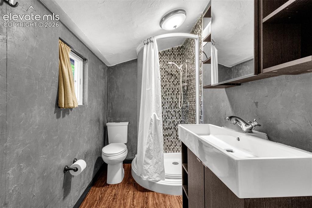 Image 12 of 21: Bathroom featuring a curved shower enclosure with mosaic tile surround, a m