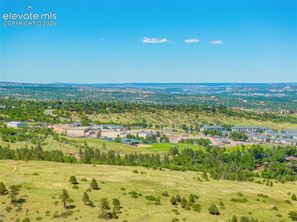 Image 21 of 21: Expansive landscape featuring rolling hills and distant urban development