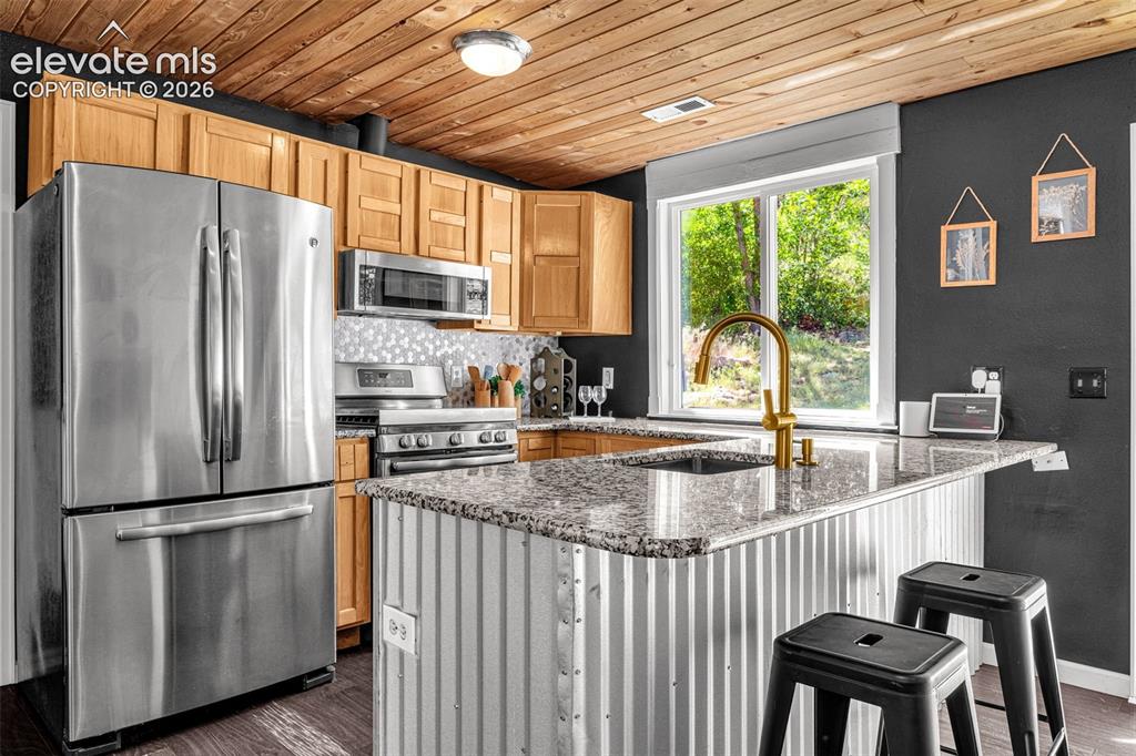 Image 5 of 21: Modern kitchen featuring stainless steel appliances, granite countertops, a