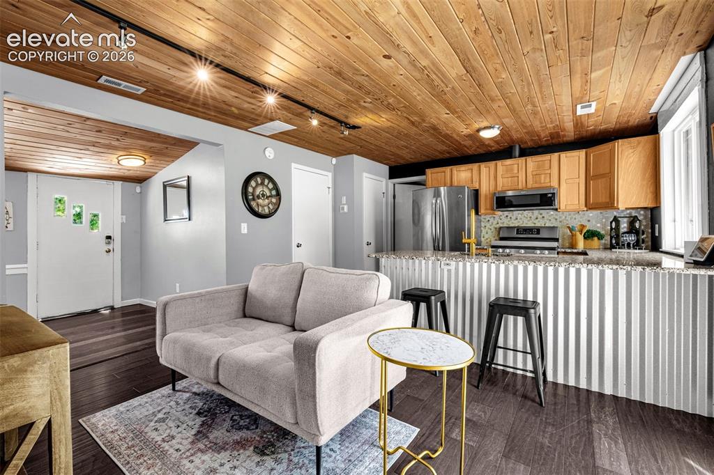 Image 7 of 21: Open-concept living space featuring wood-finish flooring, a natural wood pa