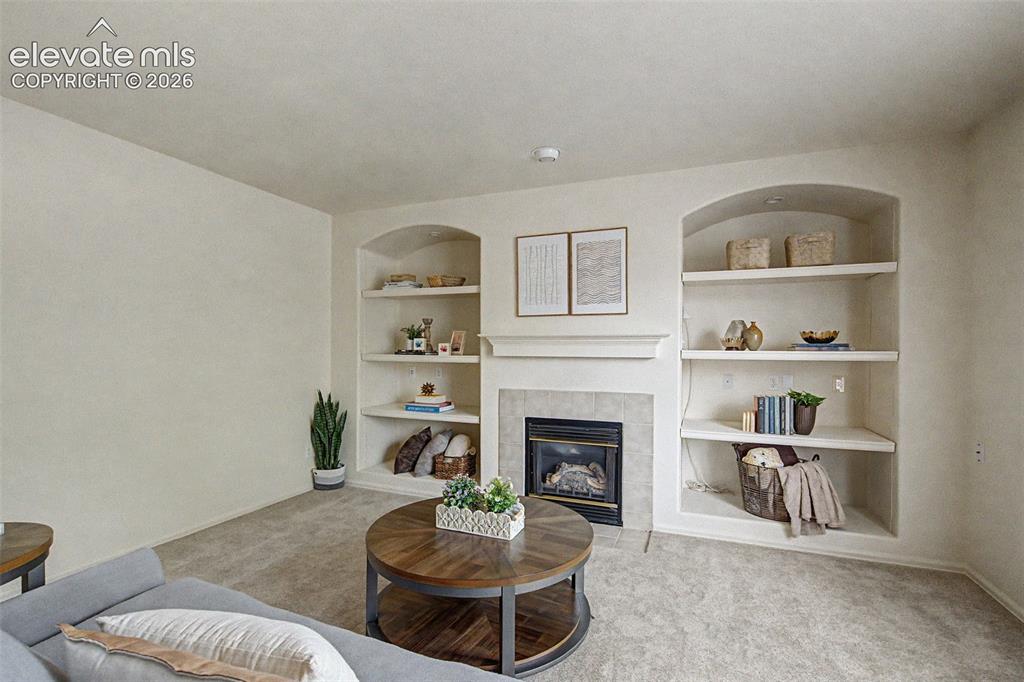 Image 5 of 22: Living Room with Built-In Shelving and Gas Fireplace