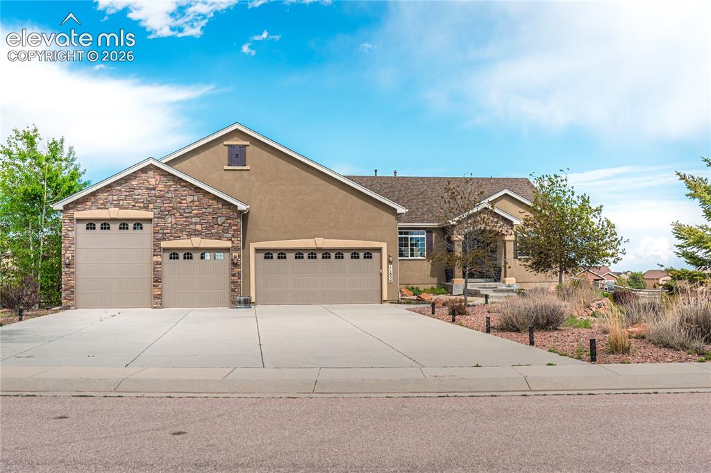 Image 1 of 50: Stucco exterior featuring stone accents and a covered entry