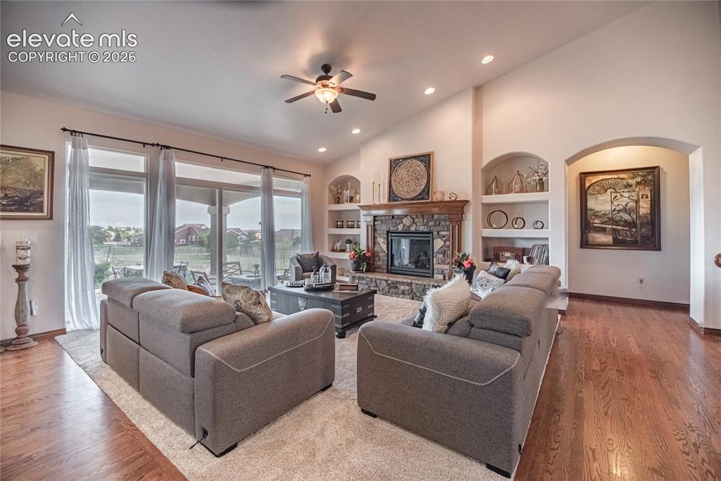 Image 12 of 50: Living area featuring vaulted ceilings, a stone-front fireplace with a wood