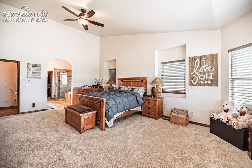 Image 14 of 50: Spacious carpeted room featuring vaulted ceilings, a ceiling fan with integ