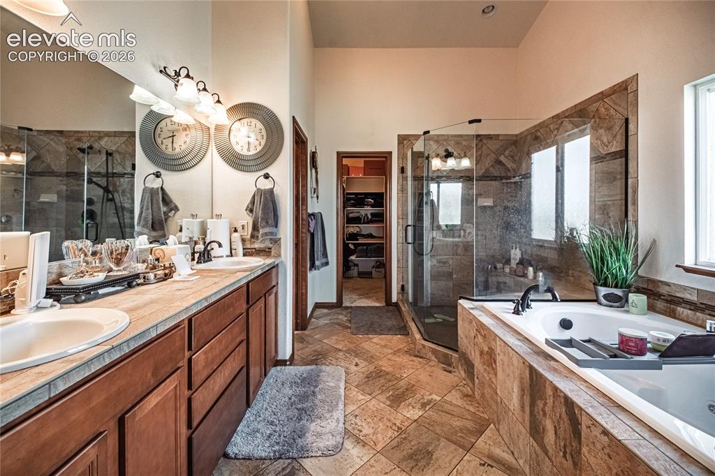 Image 15 of 50: Spacious bathroom featuring a dual vanity with undermount sinks, a large so