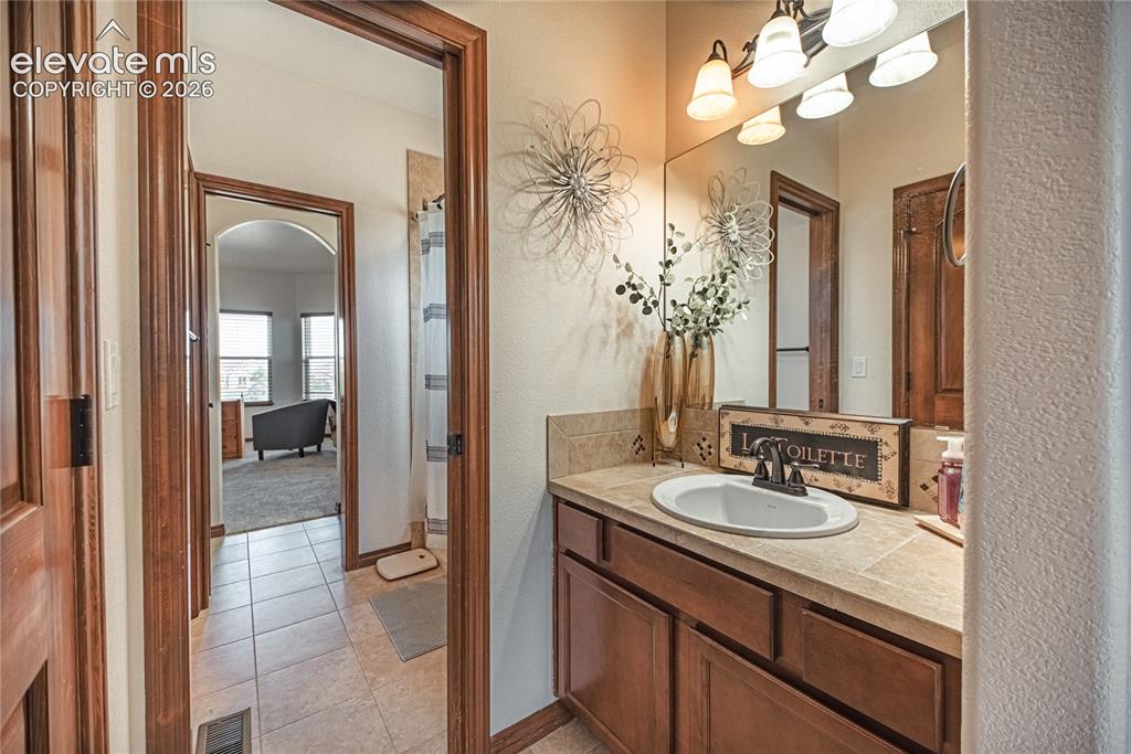Image 23 of 50: Bathroom vanity featuring a single basin sink, integrated countertop, and w
