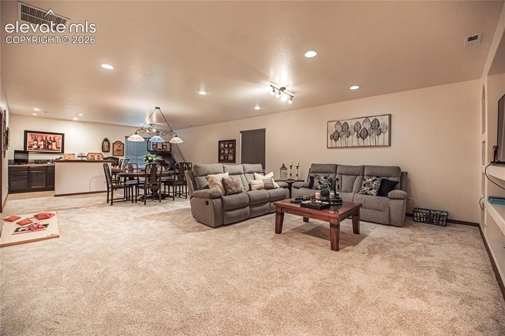 Image 25 of 50: Expansive carpeted room featuring recessed lighting and a built-in media ce