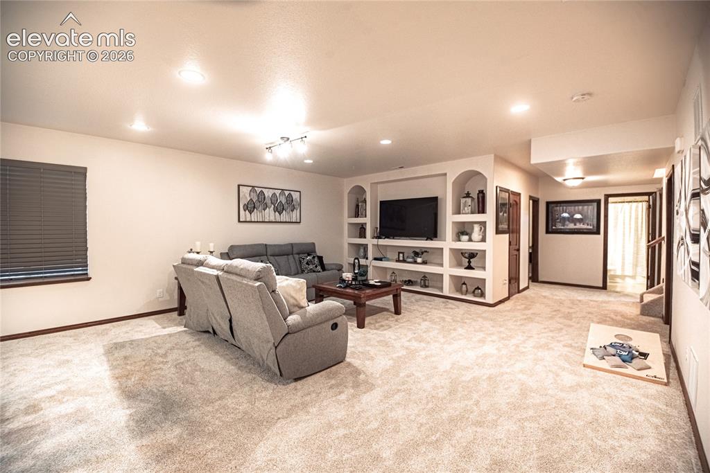Image 29 of 50: Spacious carpeted room featuring recessed lighting, built-in shelving, a wi