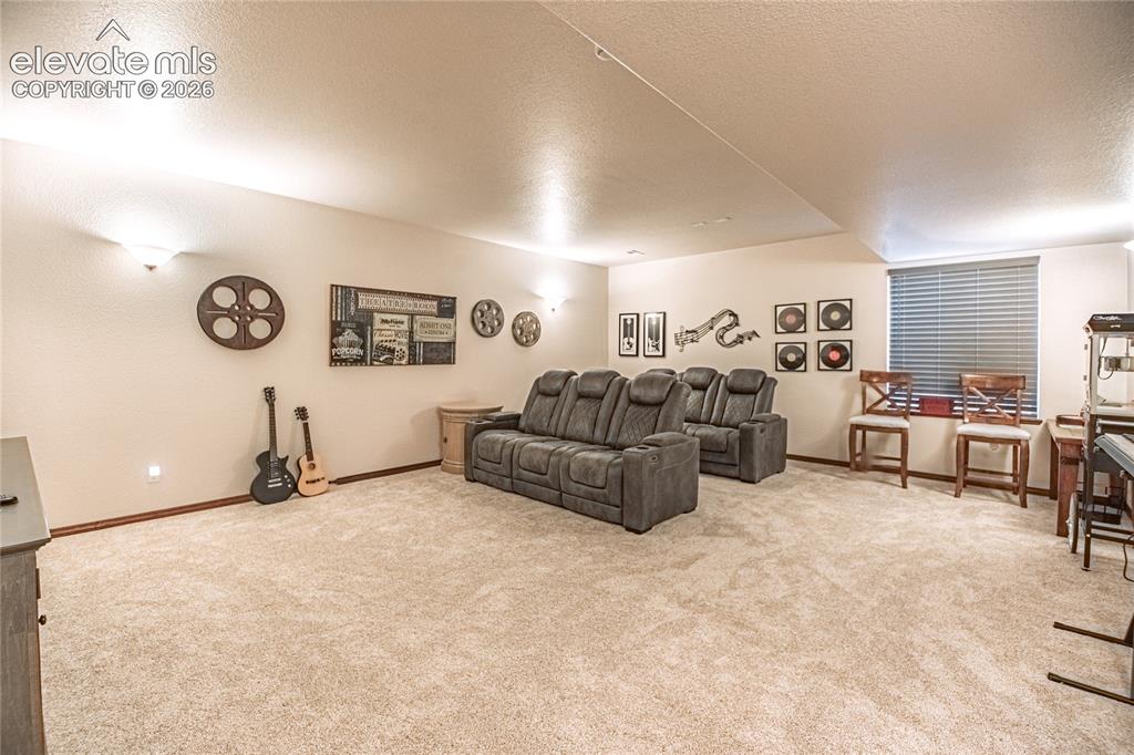 Image 30 of 50: Spacious carpeted room featuring a window with horizontal blinds, neutral w