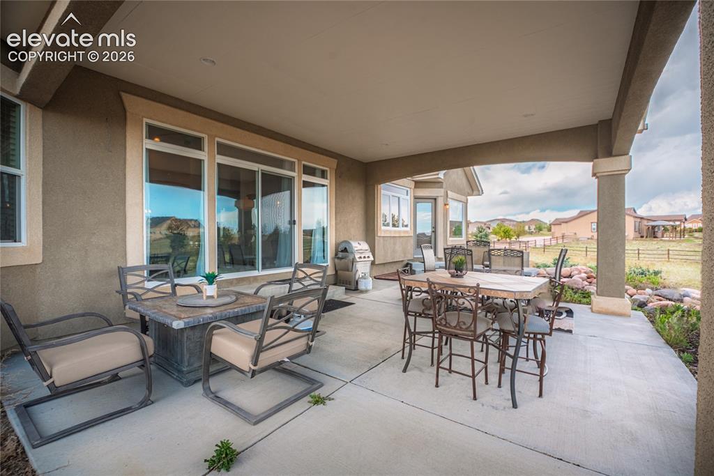Image 36 of 50: Expansive covered patio with concrete flooring, stucco exterior, and substa