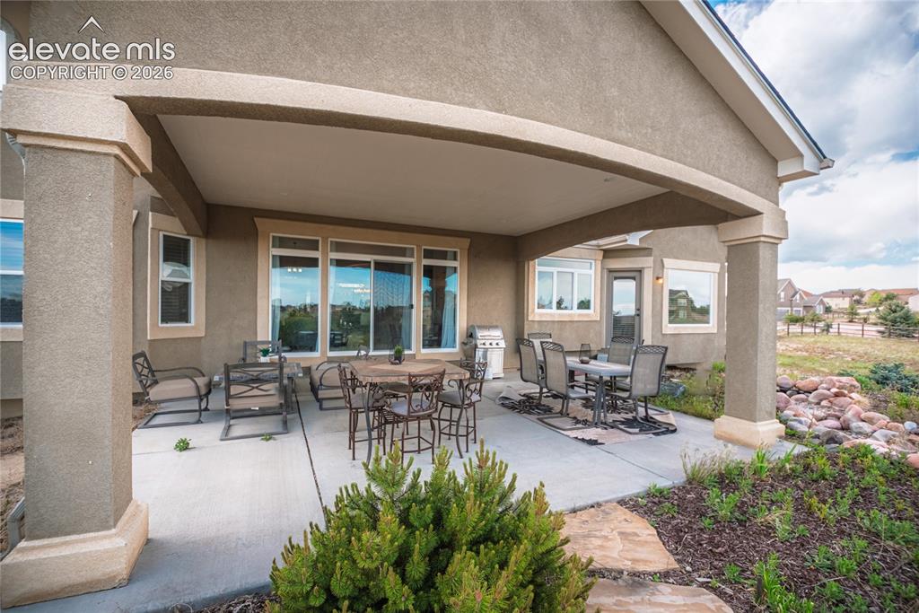 Image 37 of 50: Expansive covered patio featuring stucco columns, a concrete surface, and d