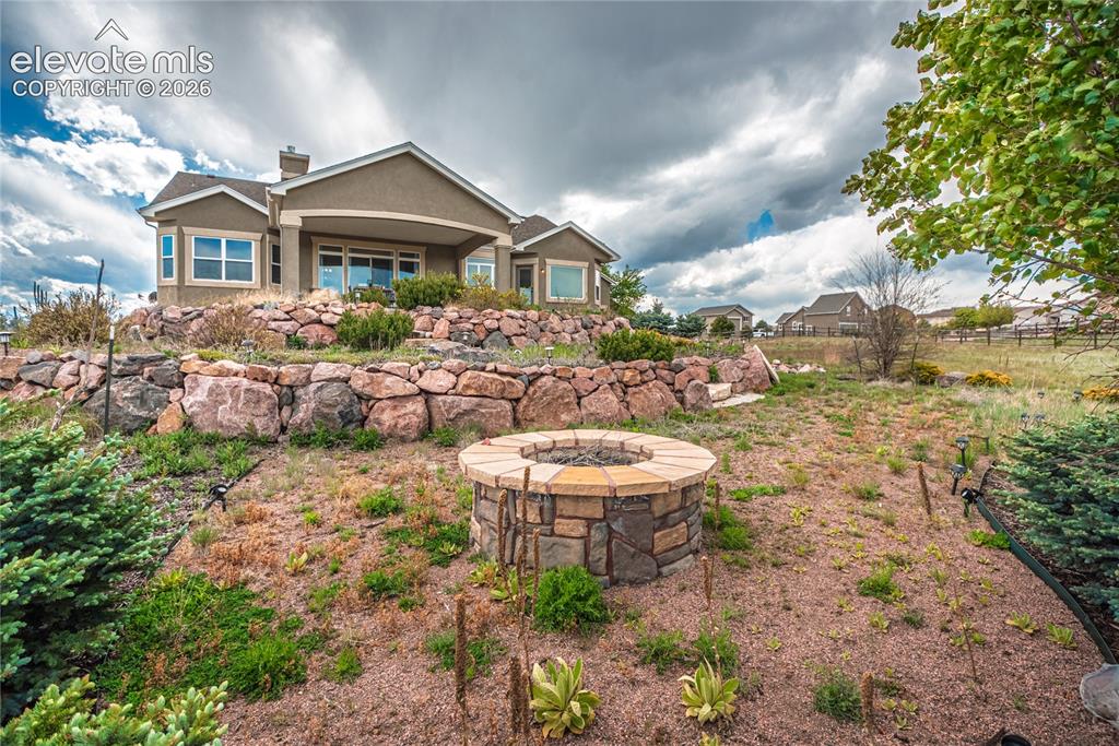 Image 39 of 50: Stone fire pit with a flagstone cap