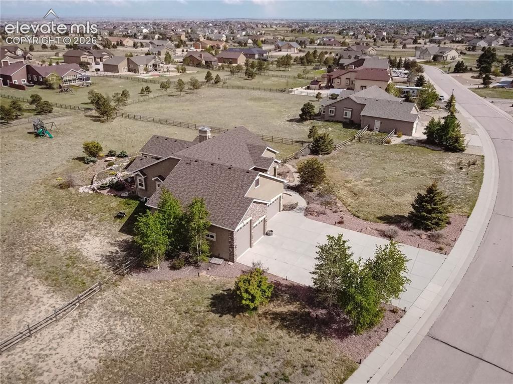 Image 41 of 50: Spacious property featuring a large driveway, established landscaping, and