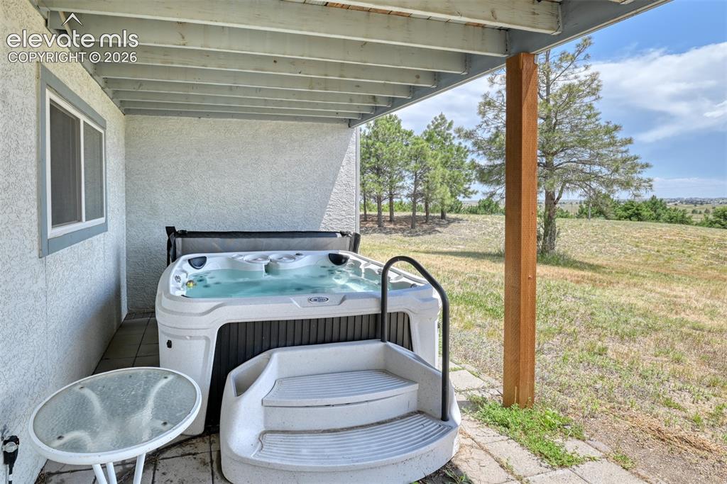 Image 31 of 44: Hot tub located just outside the slider door in the walk out basement.