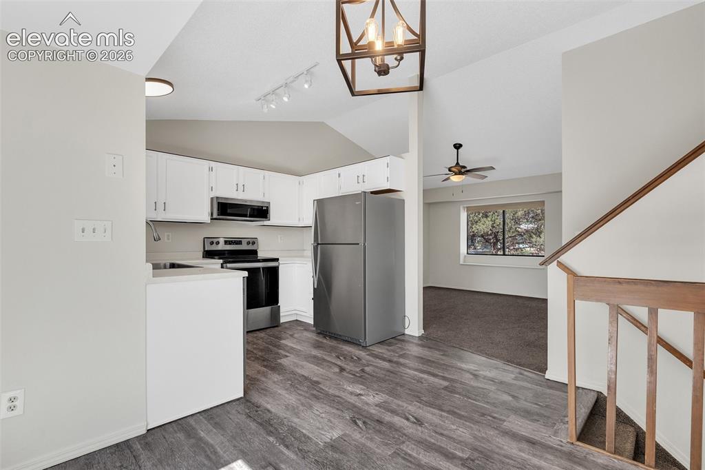 Image 11 of 33: Kitchen with white cabinetry, stainless steel appliances, and luxury vinyl
