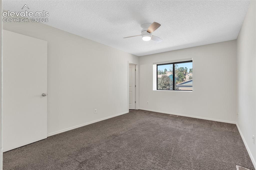 Image 15 of 33: Neutral-toned walls complement the dark gray carpeting