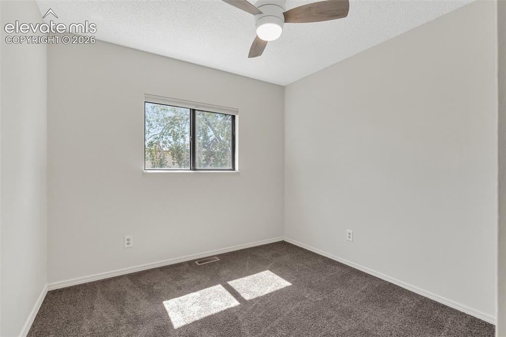 Image 20 of 33: Light-colored walls, window with natural light, dark carpeting, and a ceili