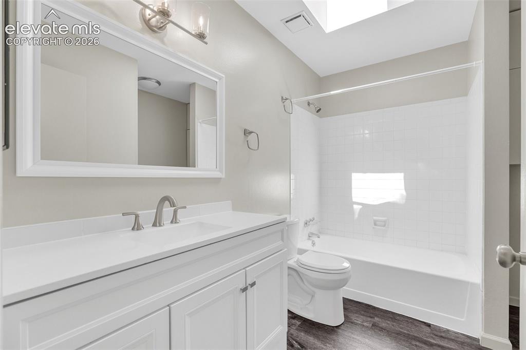 Image 22 of 33: White vanity with panel doors and a white countertop