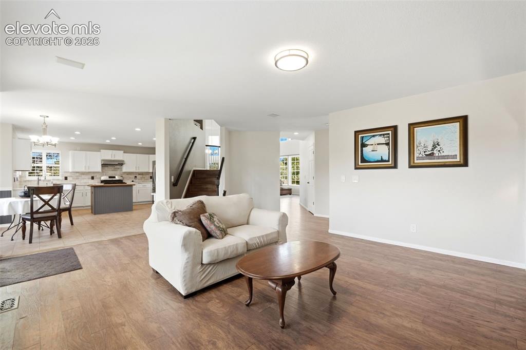 Image 12 of 43: Open-concept living space featuring wood-finish flooring, recessed lighting