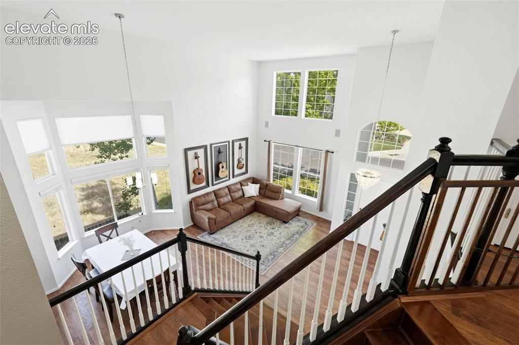 Image 15 of 43: Open-concept living space featuring high ceilings, hardwood flooring, and a