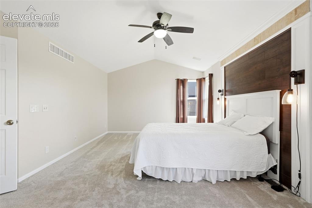 Image 17 of 43: Vaulted ceiling bedroom with light-toned wall paint and grey carpeting