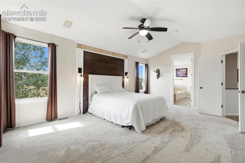 Image 19 of 43: Bedroom featuring a vaulted ceiling with a ceiling fan, light gray carpet f