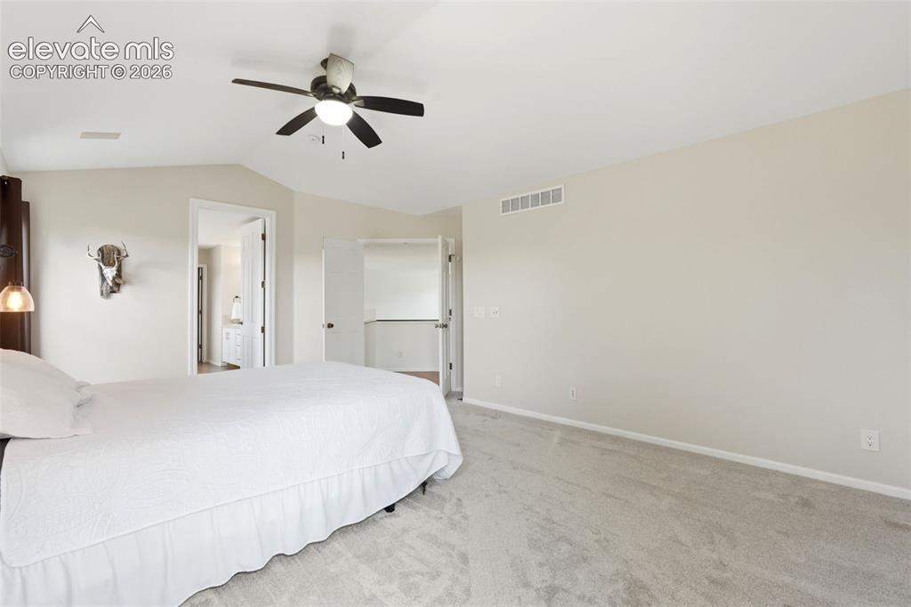 Image 20 of 43: Carpeted interior room featuring a ceiling fan, vaulted ceiling, neutral wa