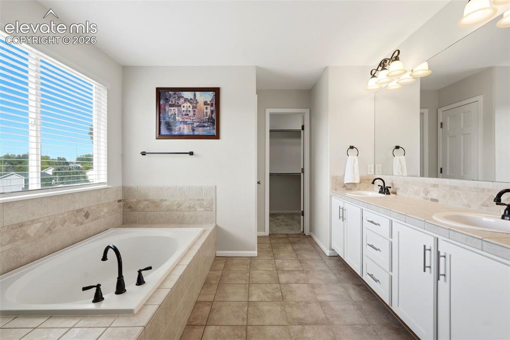 Image 21 of 43: Spacious bathroom featuring a built-in soaking tub with dark bronze fixture