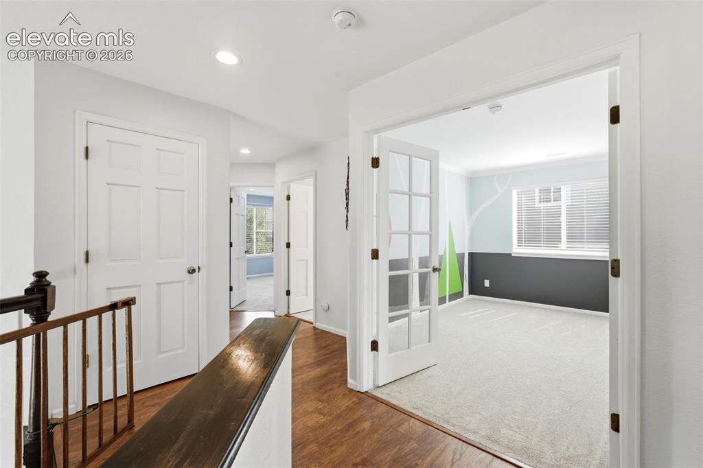 Image 25 of 43: Upper-level hallway featuring wood-finish flooring, recessed lighting, and