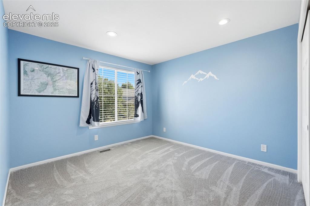 Image 29 of 43: Interior room featuring light blue walls, gray carpeting, a single window w
