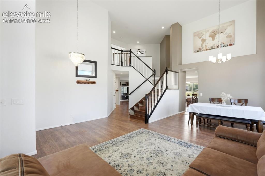 Image 3 of 43: Vaulted entry foyer featuring wood-finish flooring, a contemporary chandeli