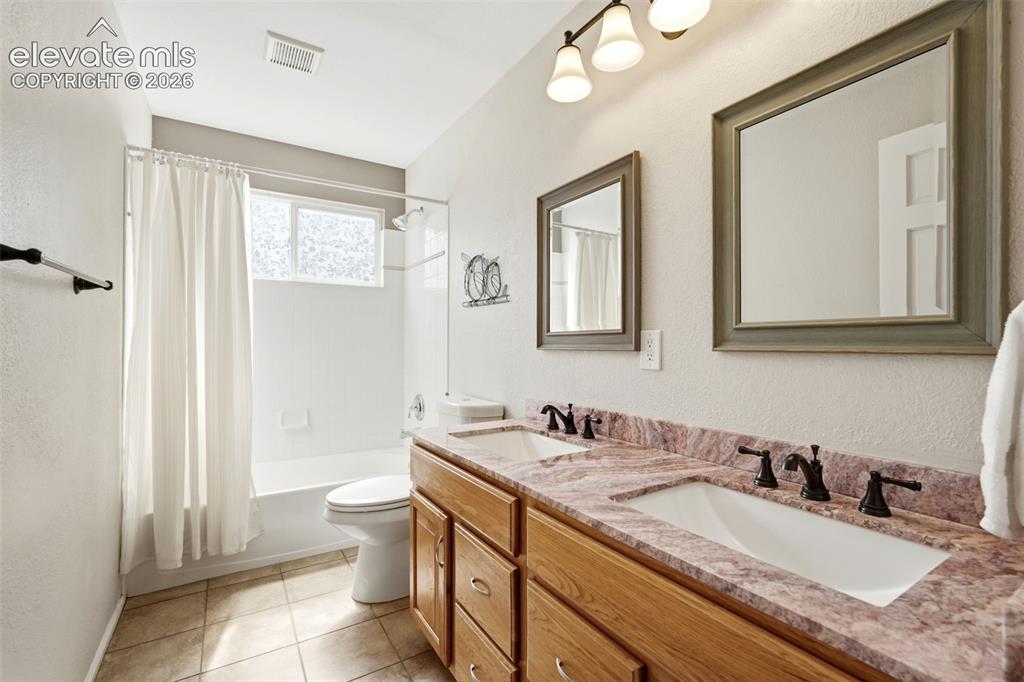 Image 31 of 43: Double vanity featuring a purple-veined countertop, dual undermount sinks,