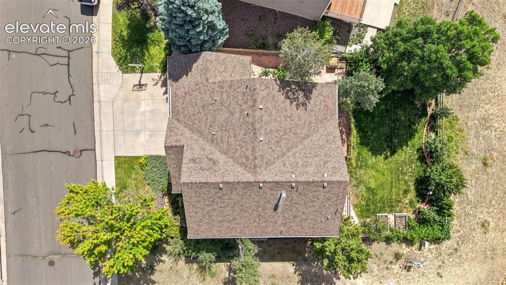 Image 40 of 43: Property featuring a pitched roofline, paved driveway, and established land