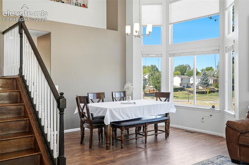 Image 5 of 43: Two-story dining area featuring a dramatic window wall with multiple window