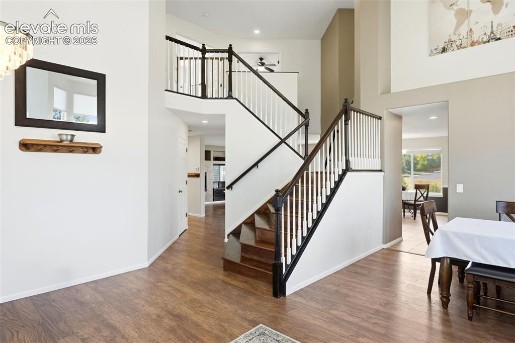Image 6 of 43: Two-story foyer featuring wood-finish flooring, a grand staircase with dark