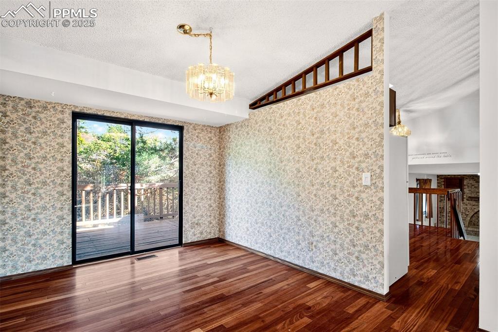 Image 12 of 50: Dining Room with walk-out to Deck and back yard - Hardwood floors "Tigerwoo